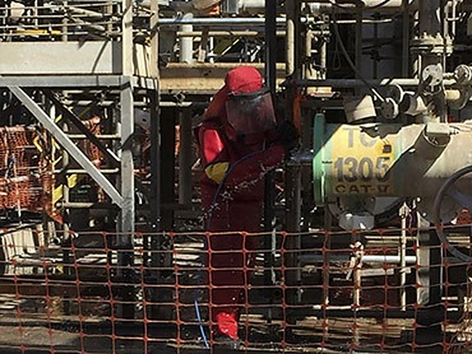 Técnico realizando hidrojateamento em estrutura metálica